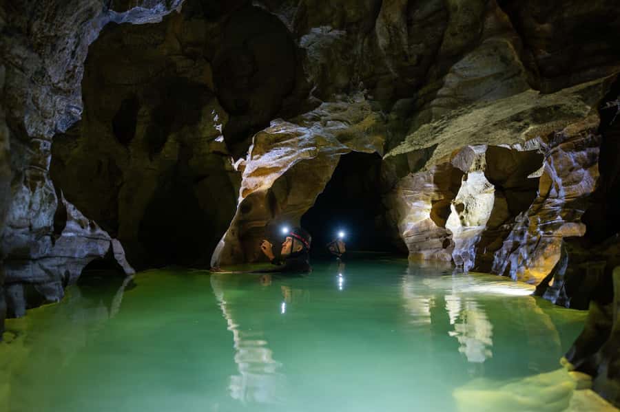 The Waitomo Experience : Okohua Glowworm Cave Tour - Entering the cave, then moving: tube floating, wading, and climbing
